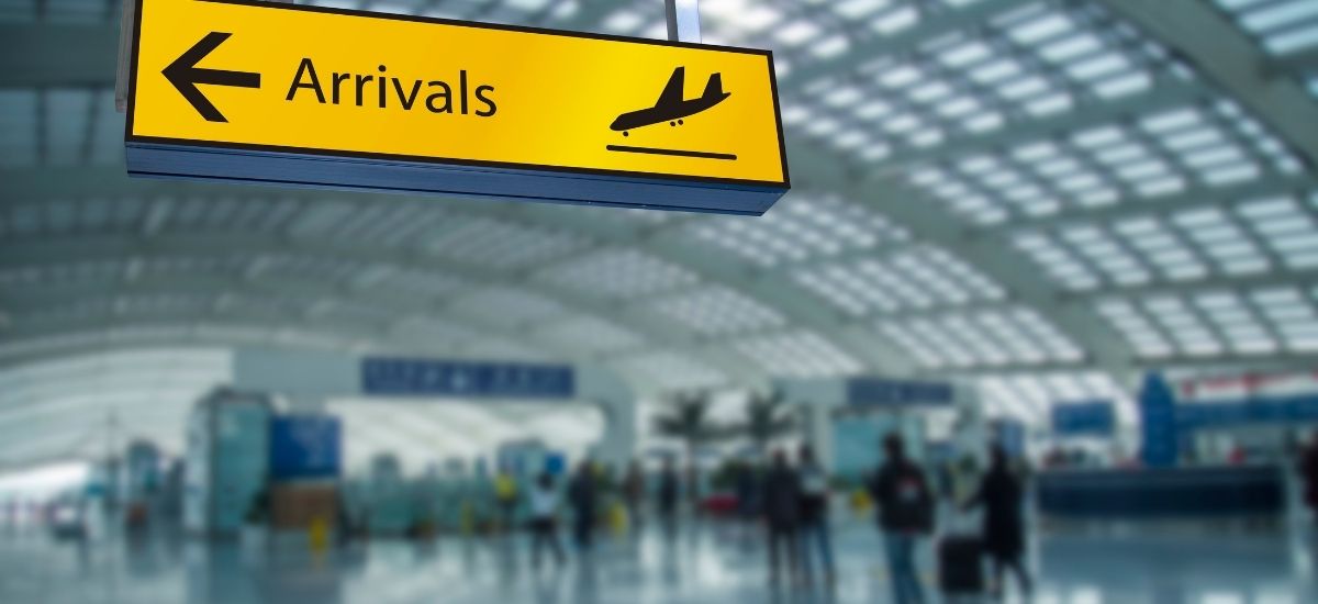 Bright modern interior of an airport arrivals hall with passengers streaming through