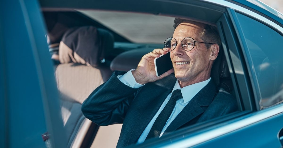 Business traveller working in the back of a corporate taxi Bristol